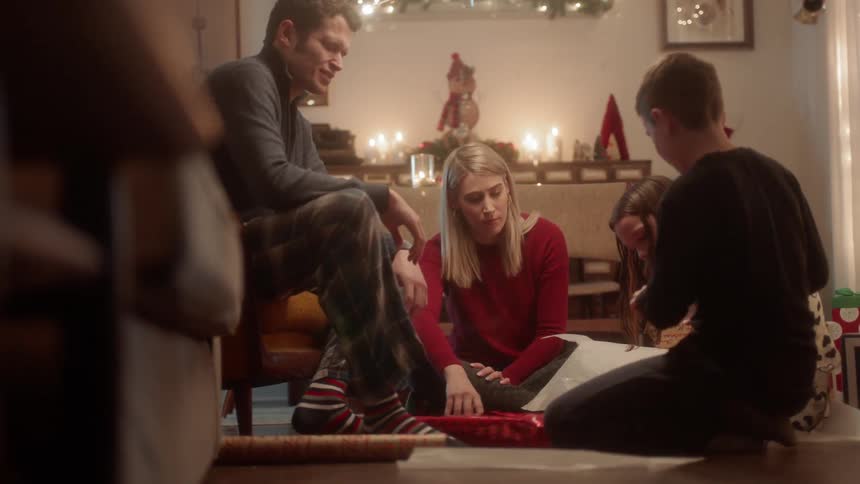 A family wraps presents together