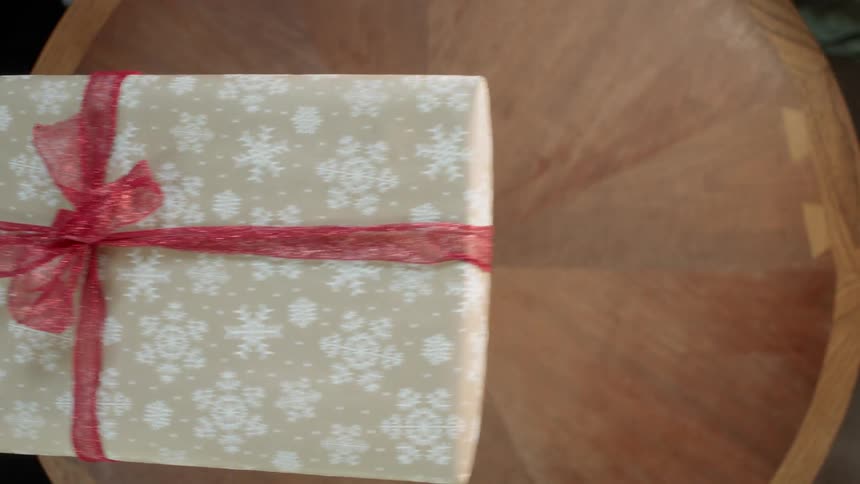 Person hands another person a wrapped present