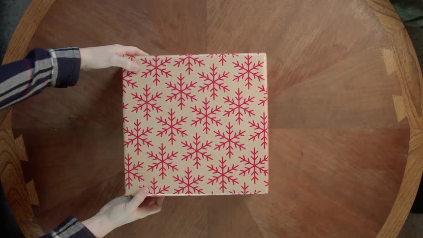A christmas gift is removed from a table