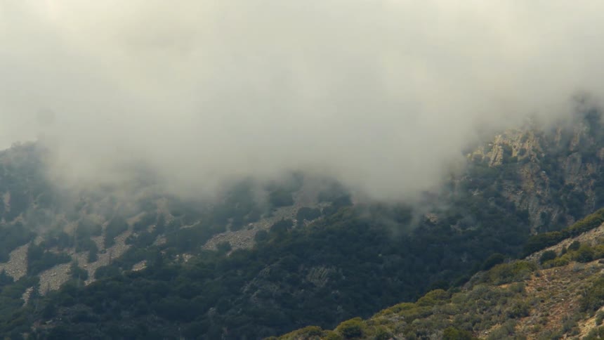 Clouds moving over a high mountain