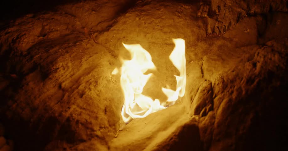 A fire burns in a rock pit