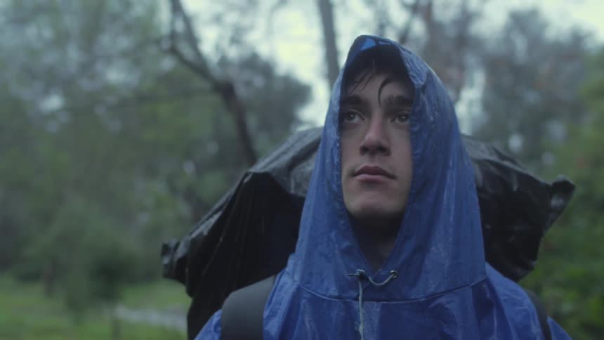 A man is hiking in the rain