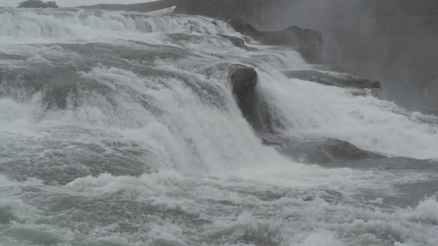 Water cascades over rocks and down a multi level waterfall