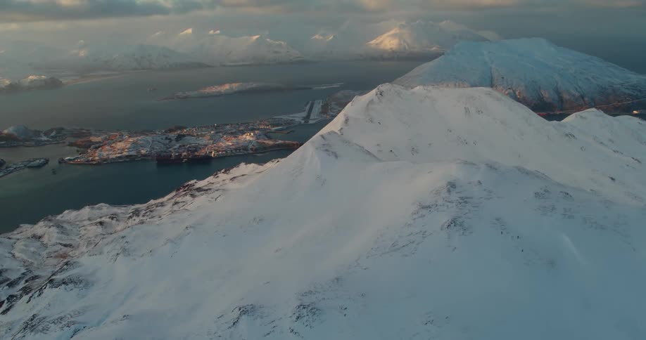 A large snow covered mountain is being flown past