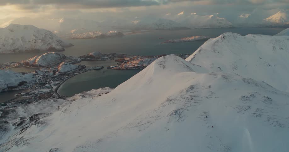 The sun sets over snowy mountains