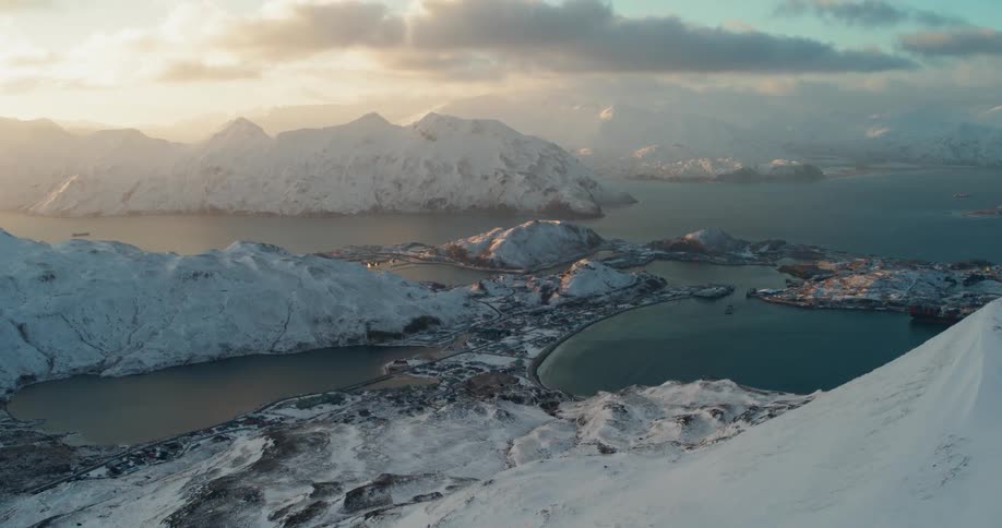 The sun sets over snowy mountains