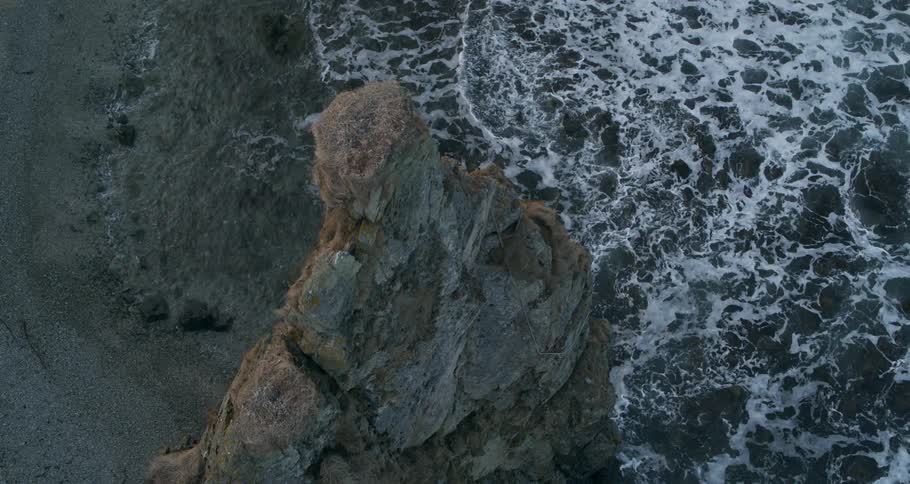 Waves come to shore around rock formations