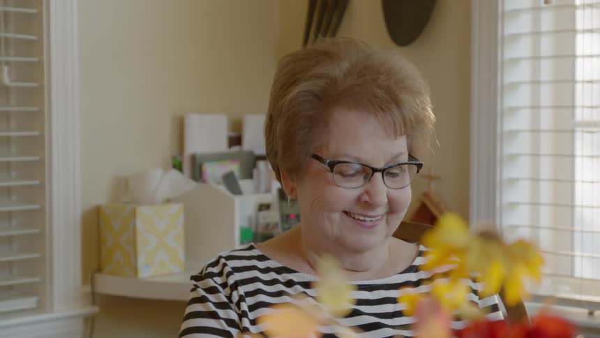 A woman sits at a table laughing and talking