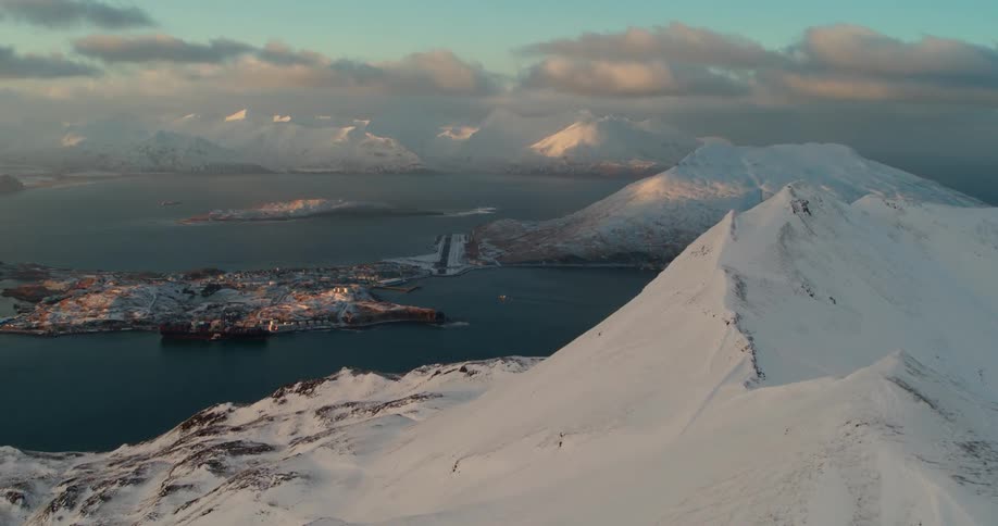Snow covered mountains near an ocean