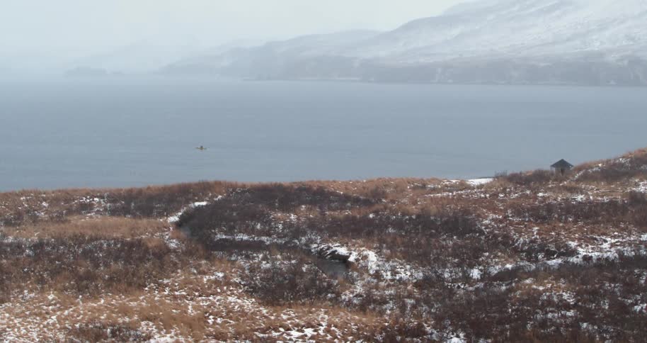 A person kayaks on the snowy sea