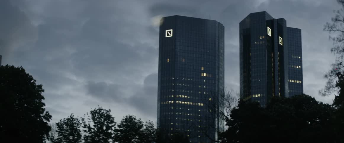 Clouds hover over two office high rises at dusk