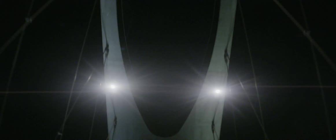 A large bridge with lights under a black night sky