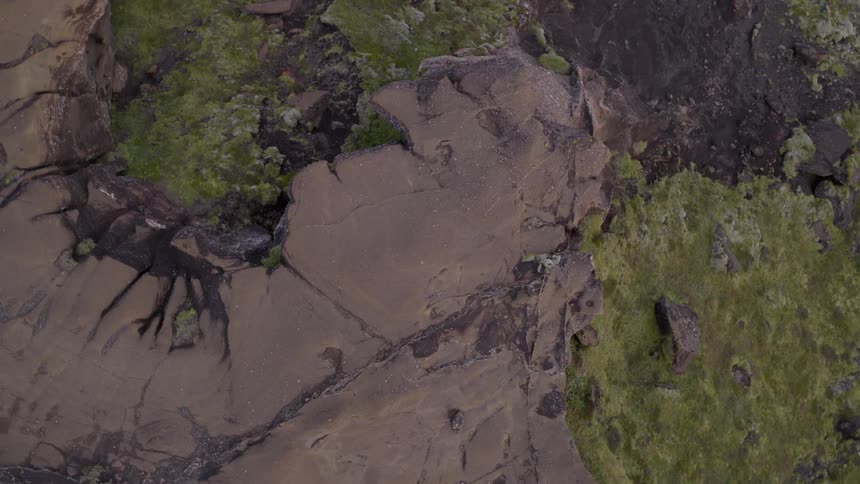 A rocky cliff side is viewed from above