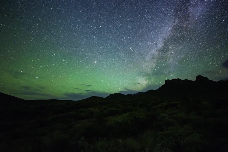 Stars and clouds float in the night sky