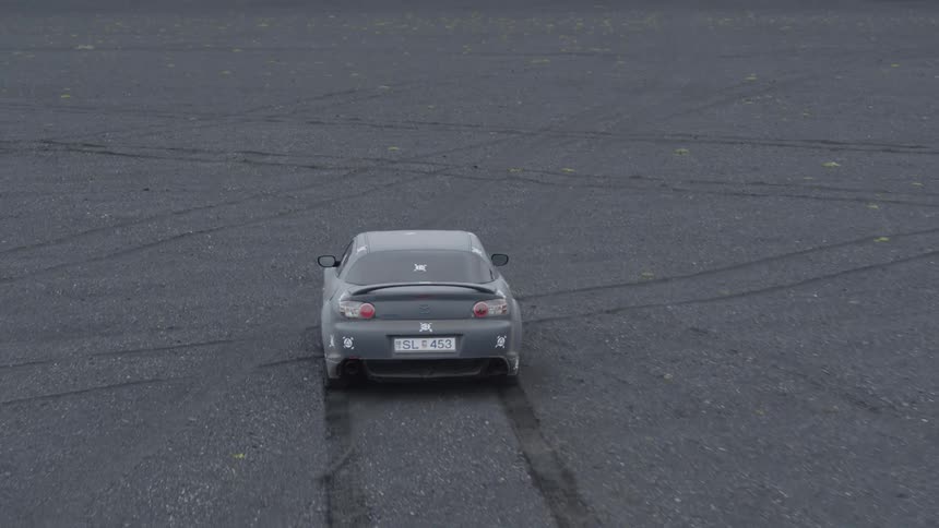 A car drives in the dirt field on a cloudy day