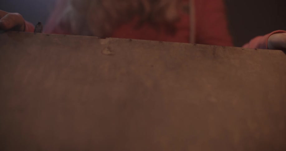 A woman is opening the lid on a wood box