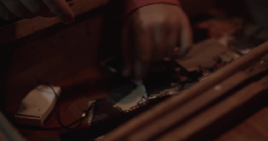 A person places a section of film negative into a drawer