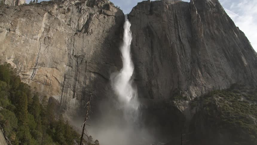 A waterfall rushes from a very high mountain