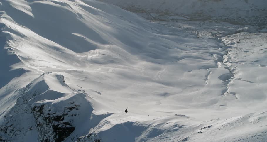 A skier hikes in snowy mountains