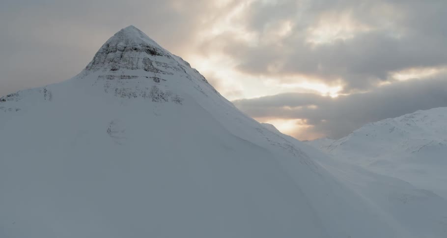 The sun sets over snowy mountains