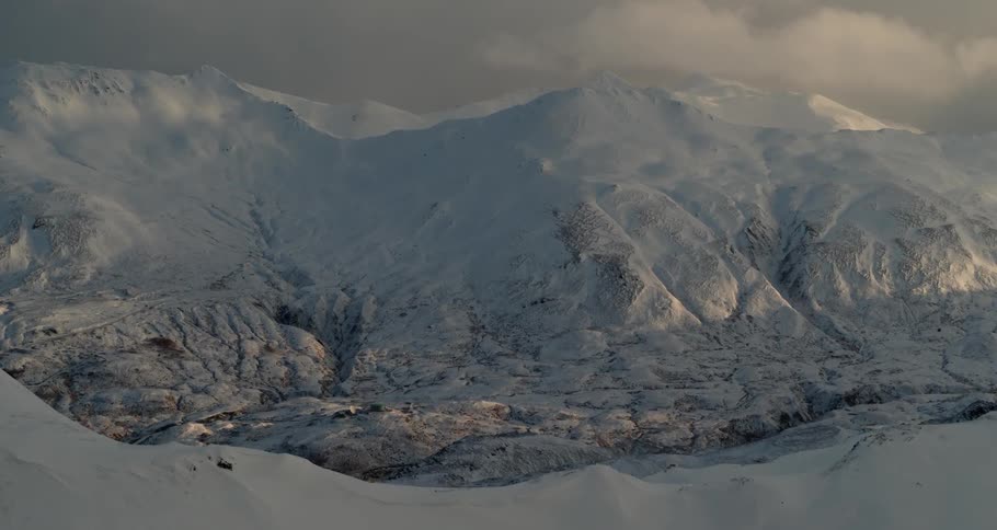 Mountain peaks and ridges are covered in snow