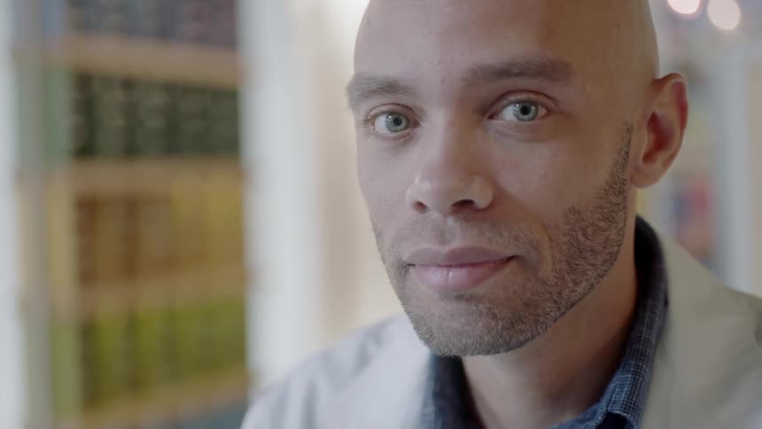 A man looks intently while in a very white room