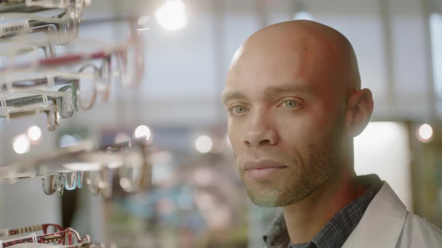 An optometrist looks at eyeglasses on display