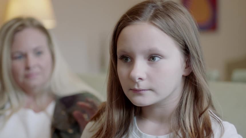 Young girl sits next to an older woman