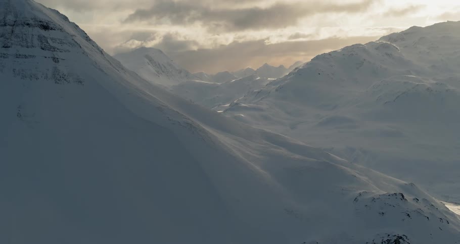 The sun sets over snowy mountains