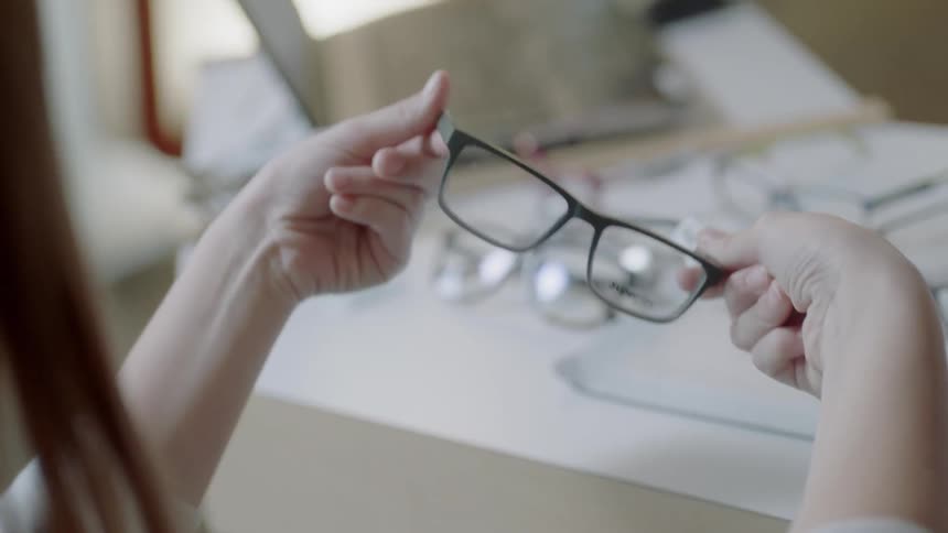 Woman examines a pair of eyeglasses