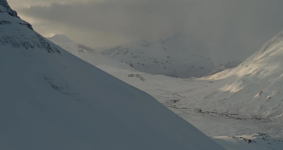 Clouds are hanging over a mountain range in winter