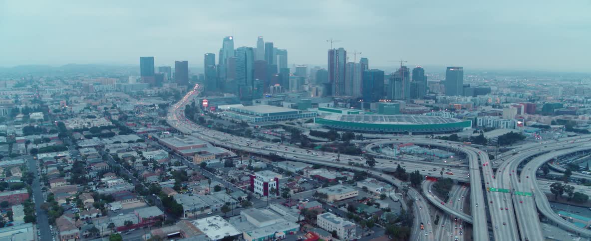 Cars drive on a city highway near skyscrapers