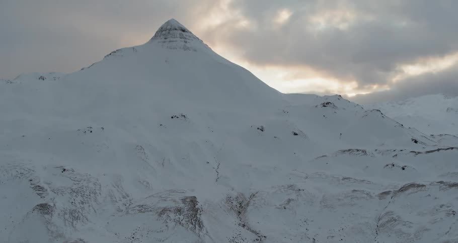 The sun sets over snowy mountains
