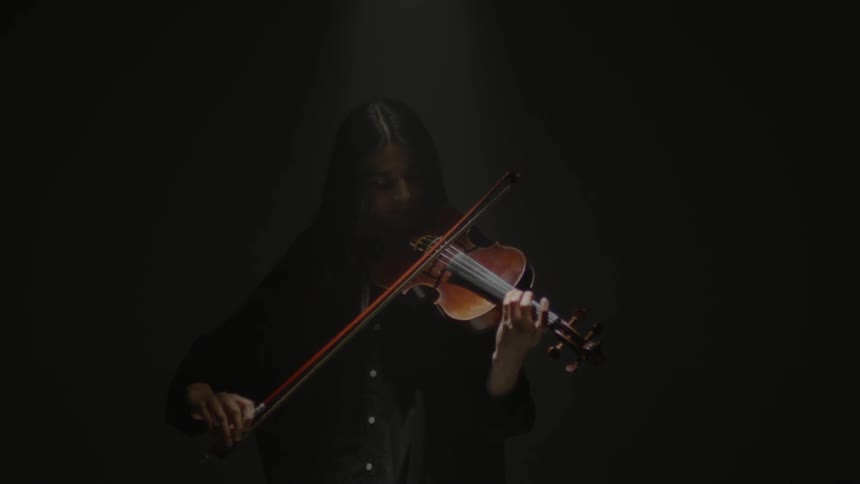 Woman plays violin using a bow