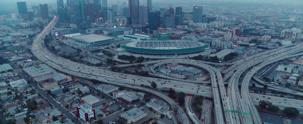 Vehicles are traveling on a freeway outside a city at dusk