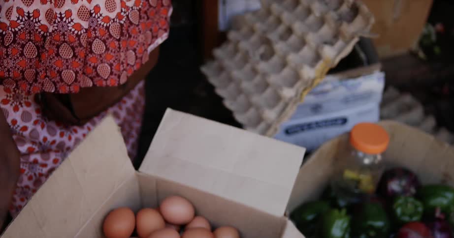 Someone is placing brown eggs into a box and sealing the box