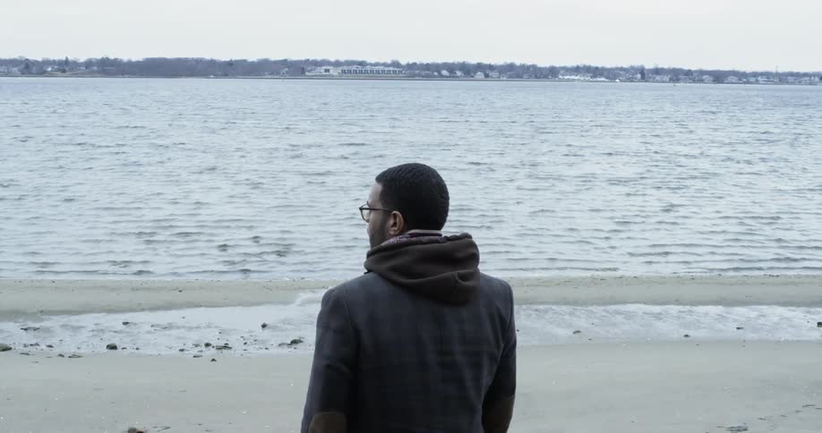A man stands on a lakeshore