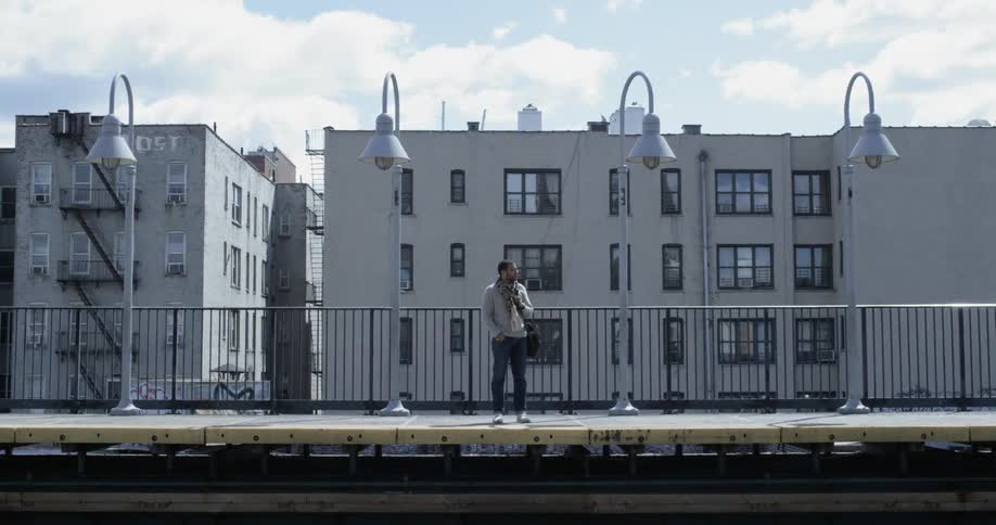 Man waits on outdoor subway platform