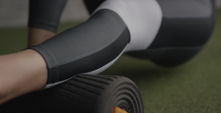 Woman uses rolled up yoga mat to exercise