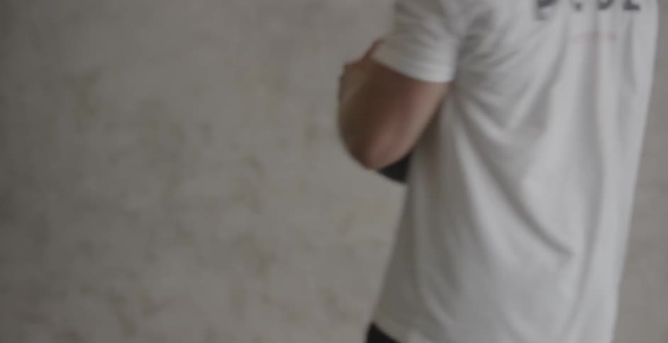 A man is swinging a medicine ball into a wall during his workout