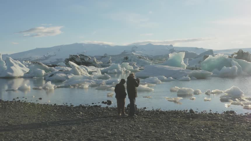 A couple watches a glacier