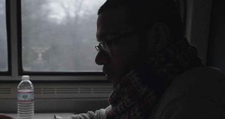 Man rides on a train sitting at a table