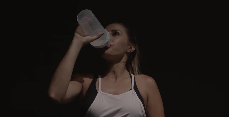 Woman drinks water after exercising