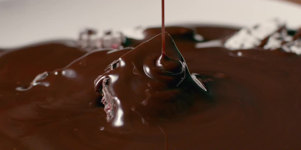 Chocolate sauce is being drizzled over a desert