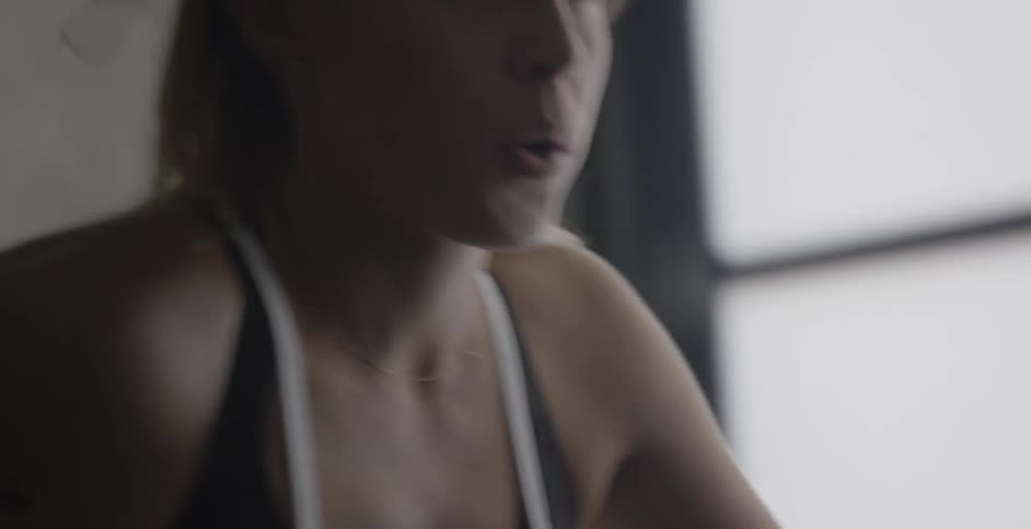 A woman is peddling on an exercise bike