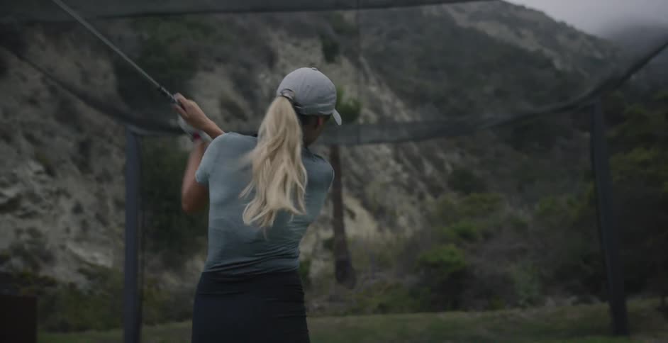 Woman practices her golf swing
