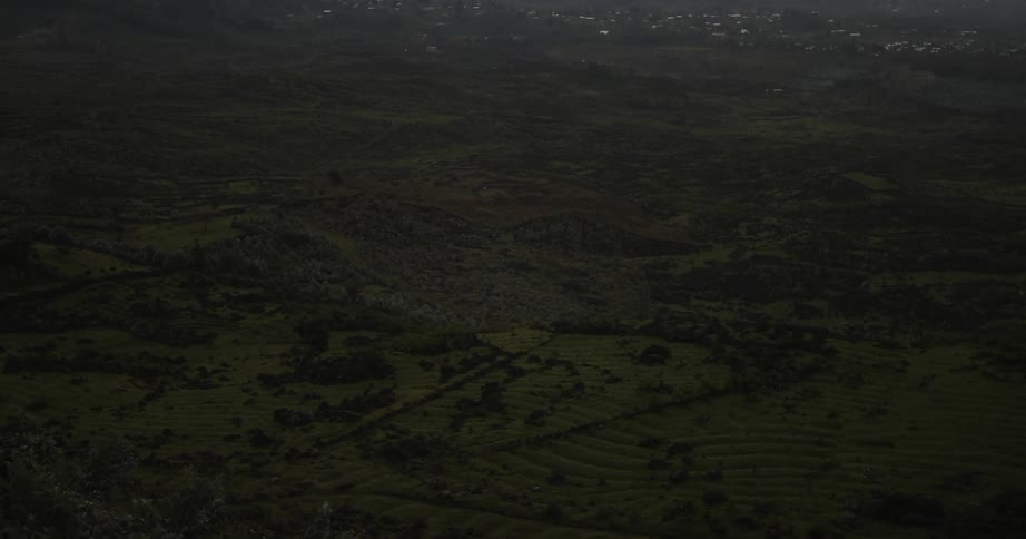 Looking down at the greens hills and fields at dusk