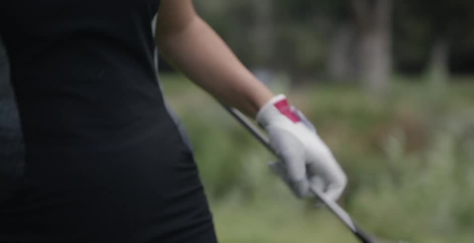 Woman removes cover from golf club