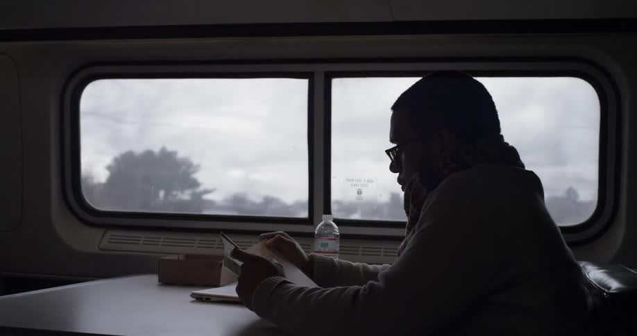 A man reads while riding on a train