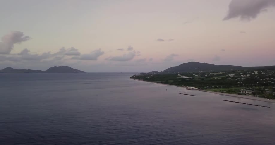 Clouds float above a shoreline at sunrise